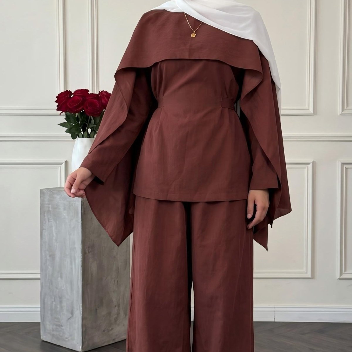 Side profile of wide-leg trousers and long-sleeve top in structured matte fabric
