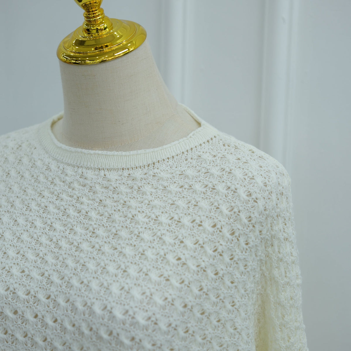 Side profile of floor-length crochet knit co-ord set showing straight silhouette