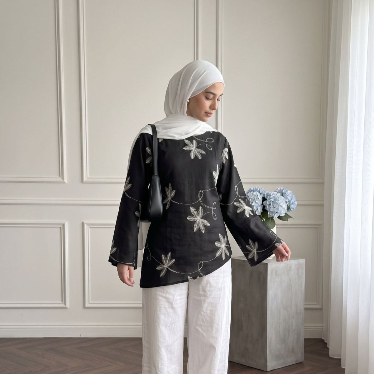 Clean flat cuff detail at the sleeve opening of the flared-sleeve embroidered top