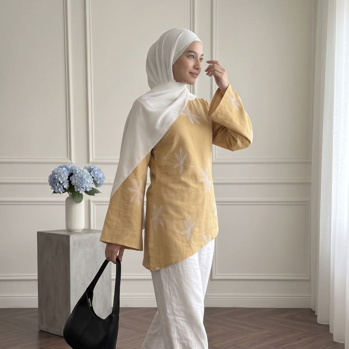 Full-length front view of white thread vine trail embroidery on modest top