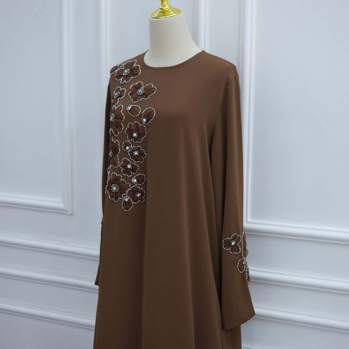 Floor-sweeping hem detail of hand-beaded 3D floral maxi dress