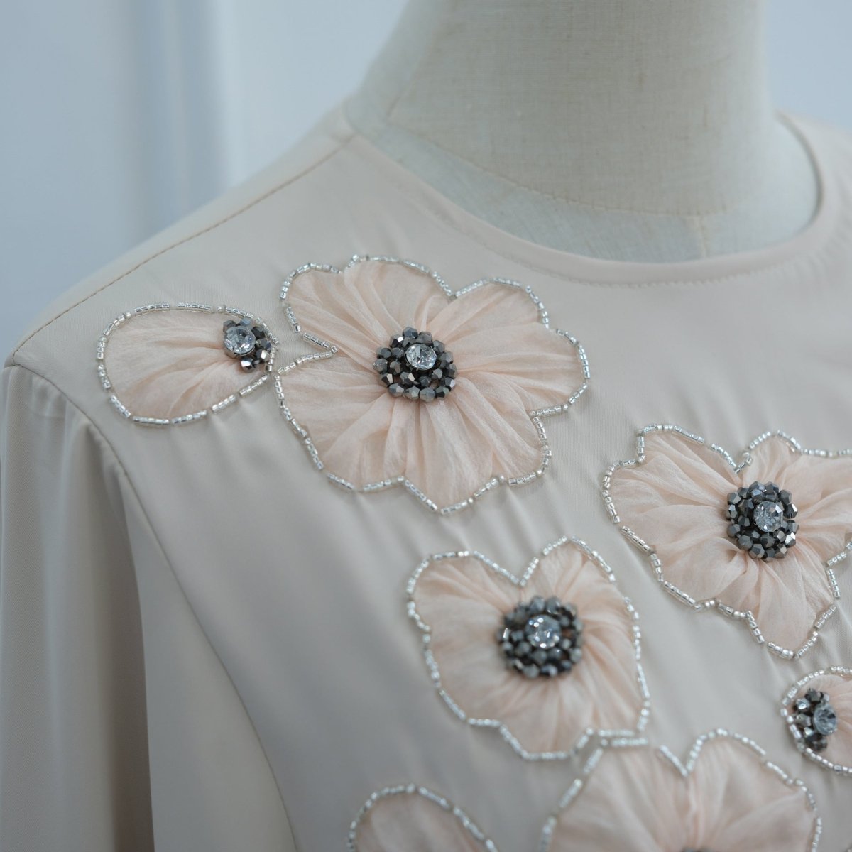 Diagonal tonal flower composition across chest on smooth matte fabric